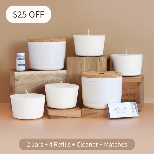 Set of white candles with wooden lids on a beige surface, with a $25 off offer displayed.